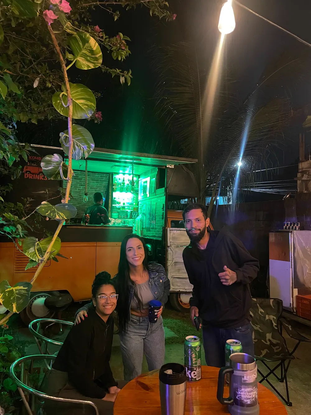 Amigos em frente à Kombi Drinks com luz neon verde